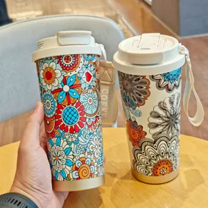 Vista detallada del vaso de café aislado estilo bohemio con diseño floral colorido y correa.