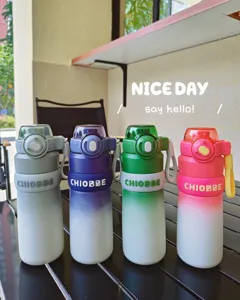 Vista detallada de botellas de agua deportivas degradadas coloridas al aire libre con pajita.