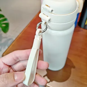 Stainless steel vacuum insulated water bottle detail showing portable handle and pop-up lid.