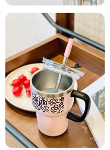 Rosa Edelstahltasse mit Griff und Strohhalm, schöne Detailaufnahme im heimischen Küchenstil.