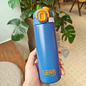 Nahaufnahme einer blauen Edelstahl Vakuum Isolierflasche mit orangenem Deckel und Sicherheitsverschluss.