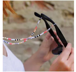 Gros plan de la chaîne de lunettes en perles colorées bohème et lanière de masque.
