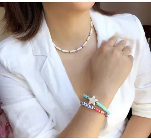 Detailed view of colorful clay bead bracelets with star charm and cute letter beads worn.