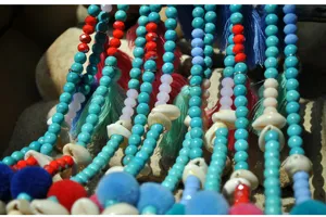 Detail shot of bohemian beach style beaded long necklace with turquoise shells and tassels.