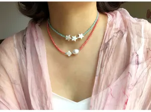 Collana doppia di perline di cristallo con stelle in conchiglia bianca e ciondolo di perla.