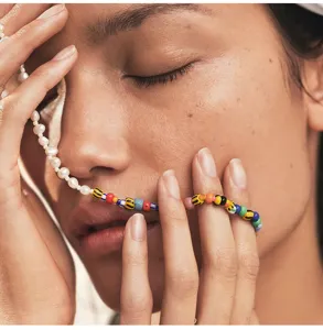 Primo piano dettagliato di collana di perle e perline colorate in stile boho indossata modella.