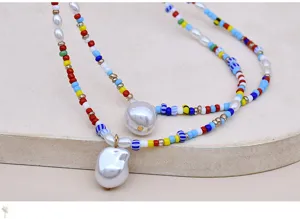 Dettaglio di una collana multistrato con perline colorate e perle barocche estive.