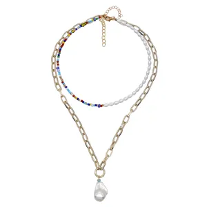 Collana a strati dorata chic con perline colorate e ciondolo di perla barocca.