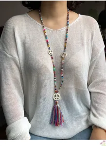 Lunga collana di perline di cristallo con ciondolo segno di pace per maglione dettaglio donna.
