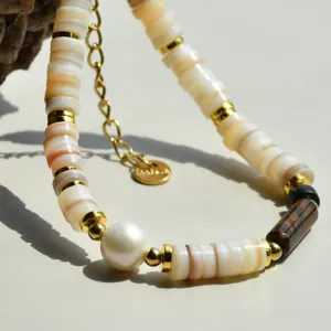 Gros plan détaillé du bracelet en perles de coquillage avec perle et œil de tigre.