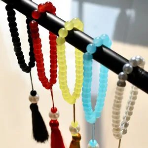 Dettaglio in primo piano di bracciali di preghiera colorati a 33 perline con nappe tradizionali.