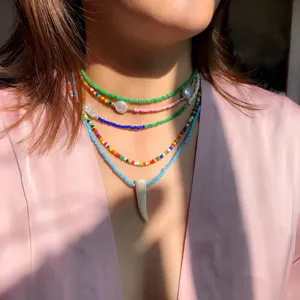 Collana girocollo multistrato con perline di riso colorate boho e ciondolo avorio da donna.