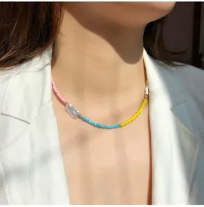 Primo piano di dettaglio della stupenda collana girocollo con perline colorate e perla.