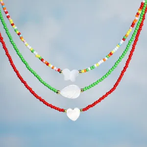 Layered colorful beaded shell necklace with butterfly, leaf and heart pendants for women.