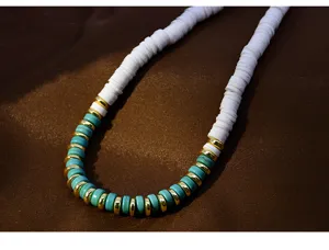 Detailed close-up of a colorful beaded necklace featuring white, turquoise, and gold spacers.