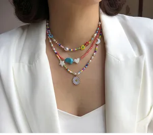 Colorful rice bead multi-layer necklace with pearl and flower charms for summer fashion style.