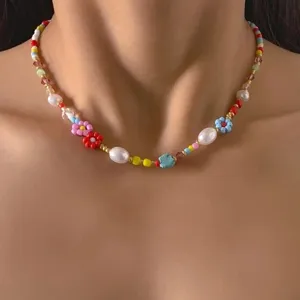 Close up detail of colorful seed bead choker necklace featuring pearls and cute tiny flower charms.