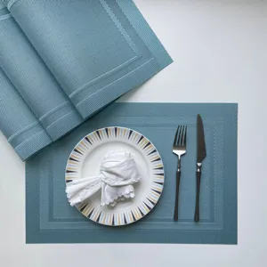 Detailed view of blue woven PVC placemat with elegant tableware setup, non-slip table mat.