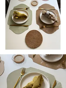 Detailed view of irregular leather placemats with white plates and gold cutlery for dining.
