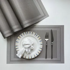 Grey PVC woven placemat detail with plate and cutlery setting for dining table decor
