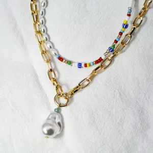 Primo piano dettagliato della collana di moda multistrato con catena d'oro e perle colorate.