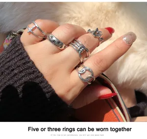 Detailed shot of vintage silver ring set featuring cross and chain designs for women.