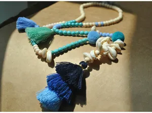 Handmade bohemian long beaded necklace with colorful tassels, turquoise beads, and natural shells.