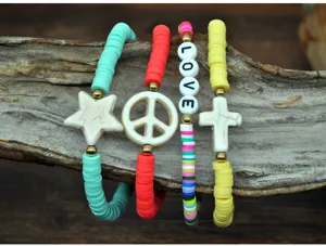 Detail shot of colorful polymer clay heishi bead bracelets with star and love charms on wood.