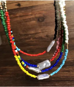 Collana girocollo boho a strati con perline colorate e ciondoli in perle barocche irregolari.