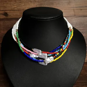 Collana girocollo multistrato boho con perline di riso colorate e perle barocche irregolari.