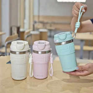 Detailed view of portable stainless steel coffee mug with silicone sleeve and straw.