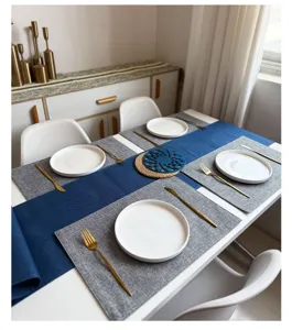 Gedetailleerd overzicht van luxe stoffen tafelloper en linnenlook placemats in modern eetkamer.