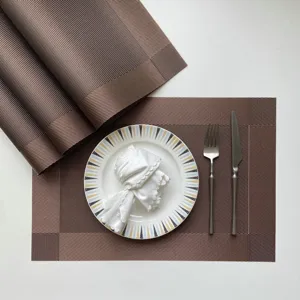 Detailed view of brown woven PVC placemat set on dining table, heat-resistant table mat detail.