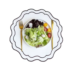 White embroidered placemat with elegant scalloped edge, perfect for dining table decor.