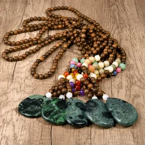 Vintage long wooden bead necklace with colorful natural stone and green pendants detail view.