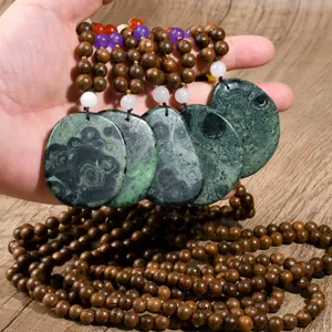 Detail of vintage natural stone irregular pendant necklace with wooden beads and colorful accents.