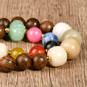 Close-up detail of mixed wooden and colorful gemstone beads bracelet texture and craftsmanship.