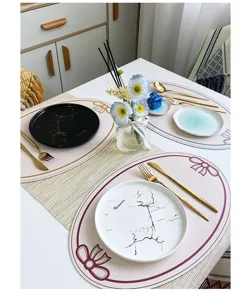 Detail shot of French luxury leather placemat with bow print, elegant table setting.