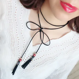 Chic black suede choker necklace with elegant tassels and bow tie, perfect fashion accessory.
