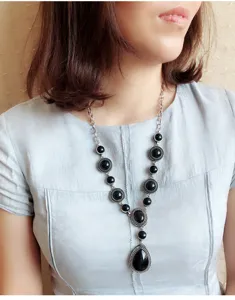 Vintage silver tone black stone teardrop pendant necklace detail showing intricate metal work.