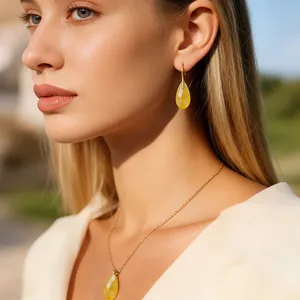 Elegant teardrop gemstone earrings and matching necklace set in gold-tone finish for women.