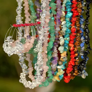 Detail shot of colorful crystal chip stone necklaces and hoop earrings in beach style.