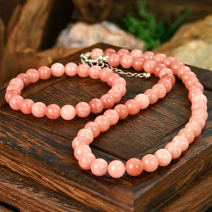 Detailed closeup view of pink sunstone beaded necklace and bracelet jewelry set details.