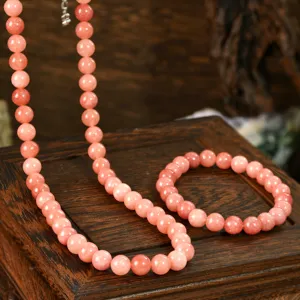 Close-up detail of the elegant pink sunstone beaded necklace and matching bracelet set.