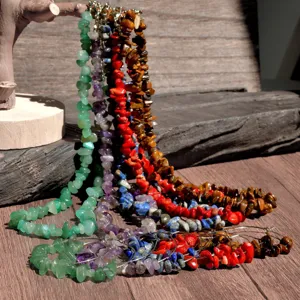 Detail close-up of colorful chipped stone necklace and earrings set on wooden display.