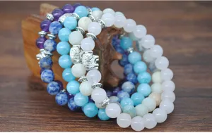 Nahaufnahme von bunten Naturstein Perlenarmbändern mit silbernen Elefanten-Charms.