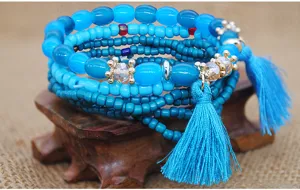 Detalle de pulsera de cuentas azules multicapa bohemia con borlas y diseño étnico.