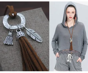 Elegante collar largo de suéter bohemio con cordón de ante y borlas metálicas.