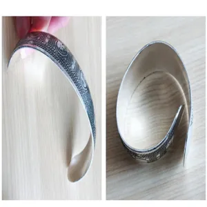 Vista dettagliata del bracciale rigido aperto in metallo inciso retrò, gioiello vintage.