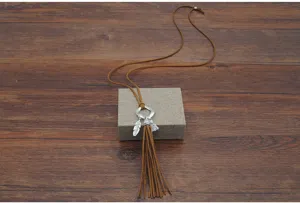 Primer plano detallado del collar largo de borla de cuero bohemio, amuletos de plumas de aleación.